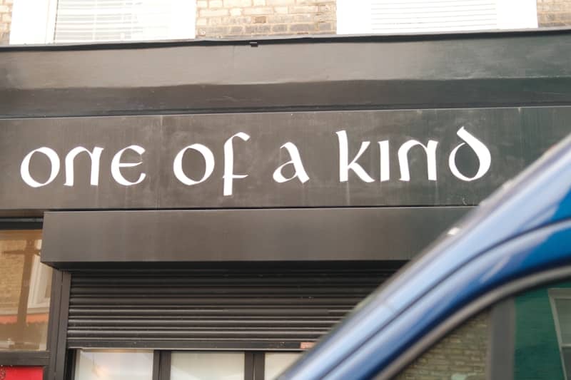 A store sign reads "one of a kind"