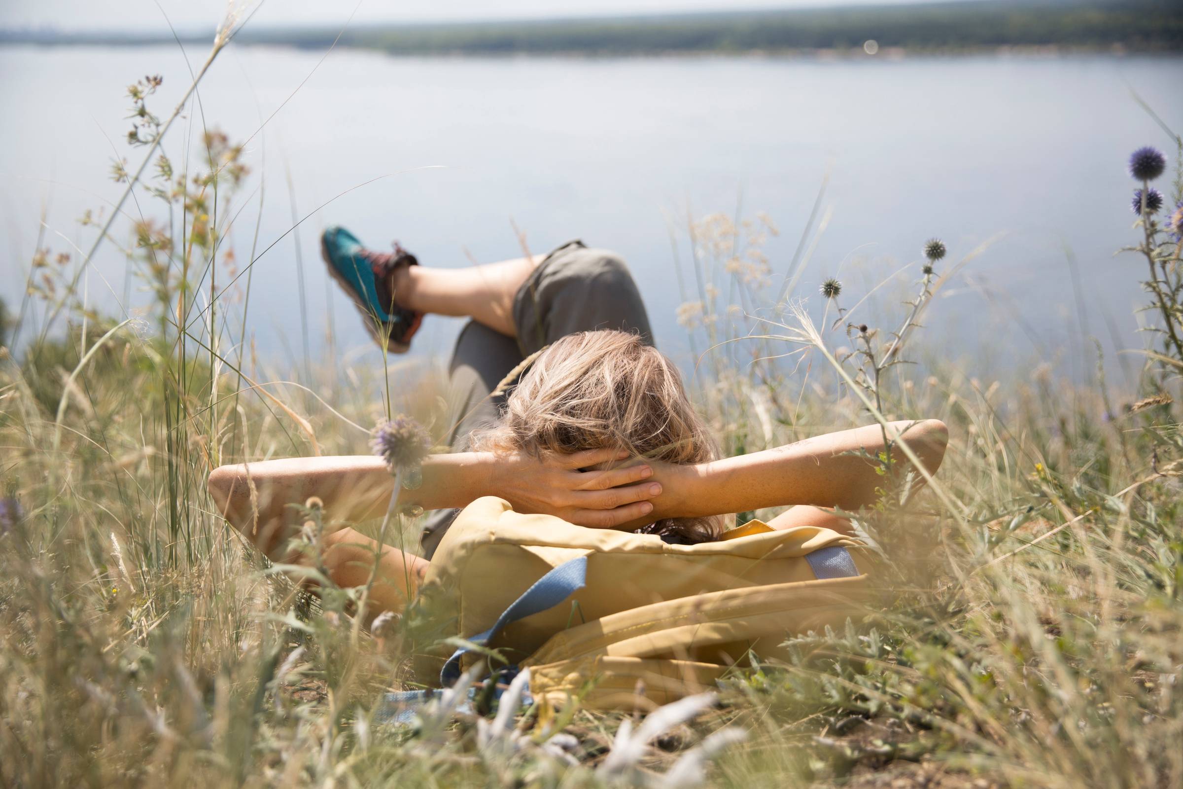Woman kicked back and relaxing beside lake