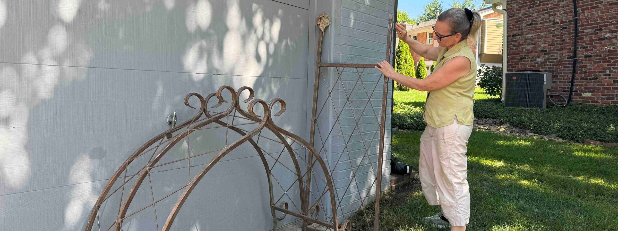 Woman sanding a garden arch