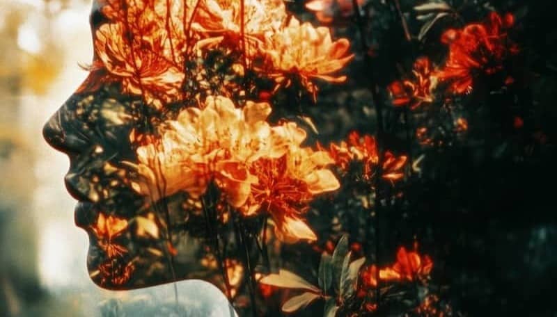 A double exposure of a woman's face with flowers in her hair
