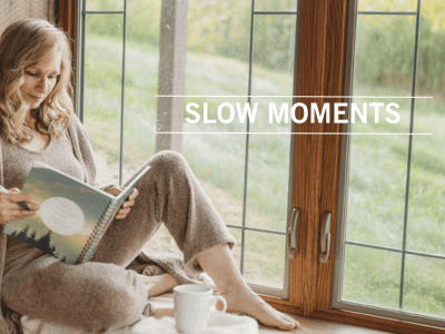 woman sitting on window ledge reading a journal