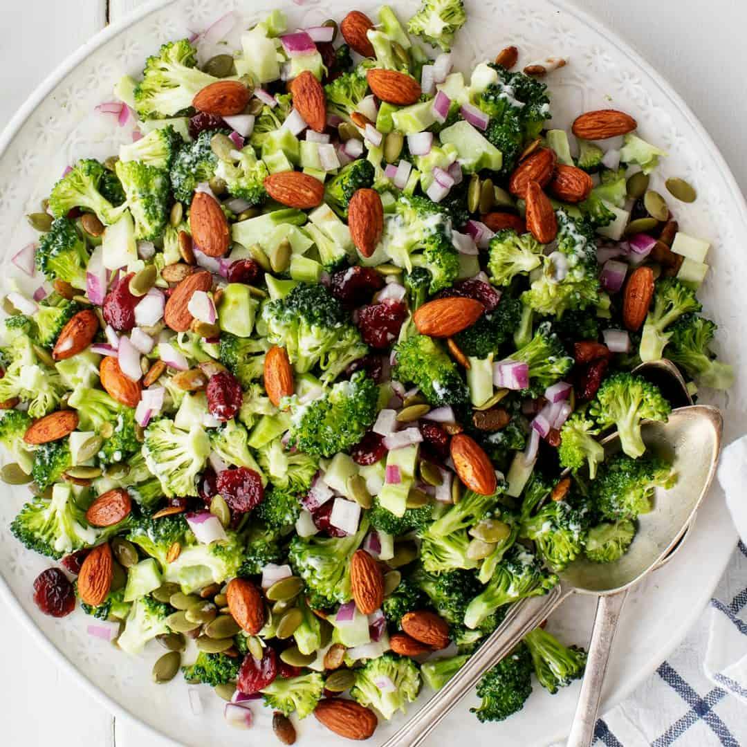 Broccoli salad on a plate with serving spoons