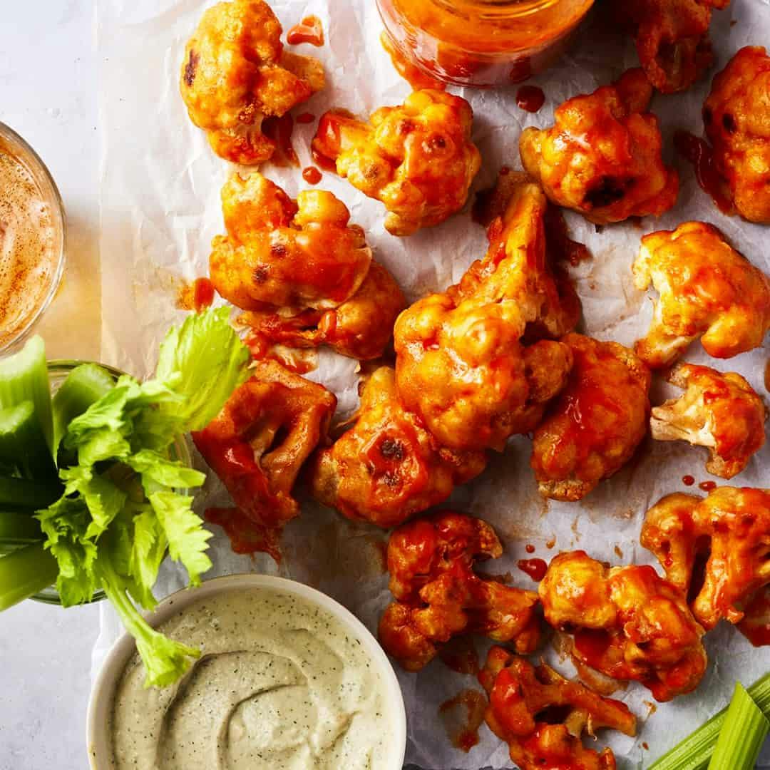 Buffalo cauliflower wings with celery and vegan ranch dipping sauce