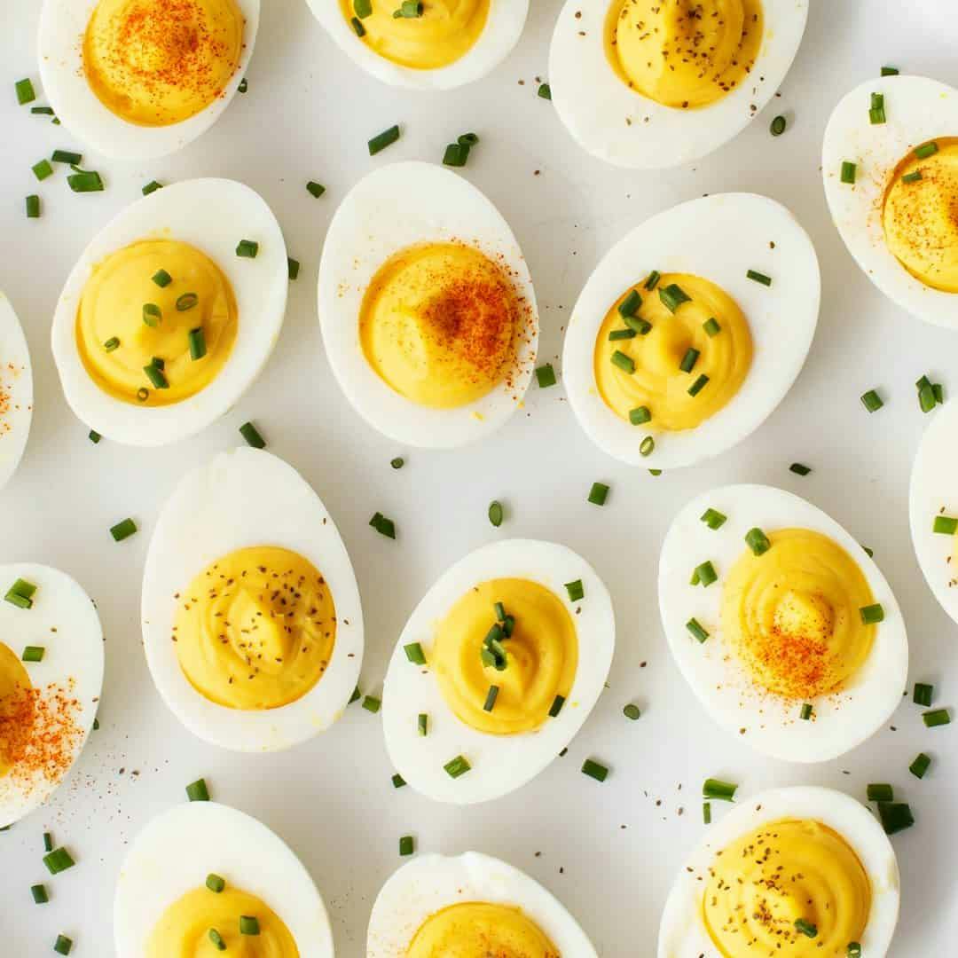 Deviled eggs topped with smoked paprika, chopped chives, or celery seed