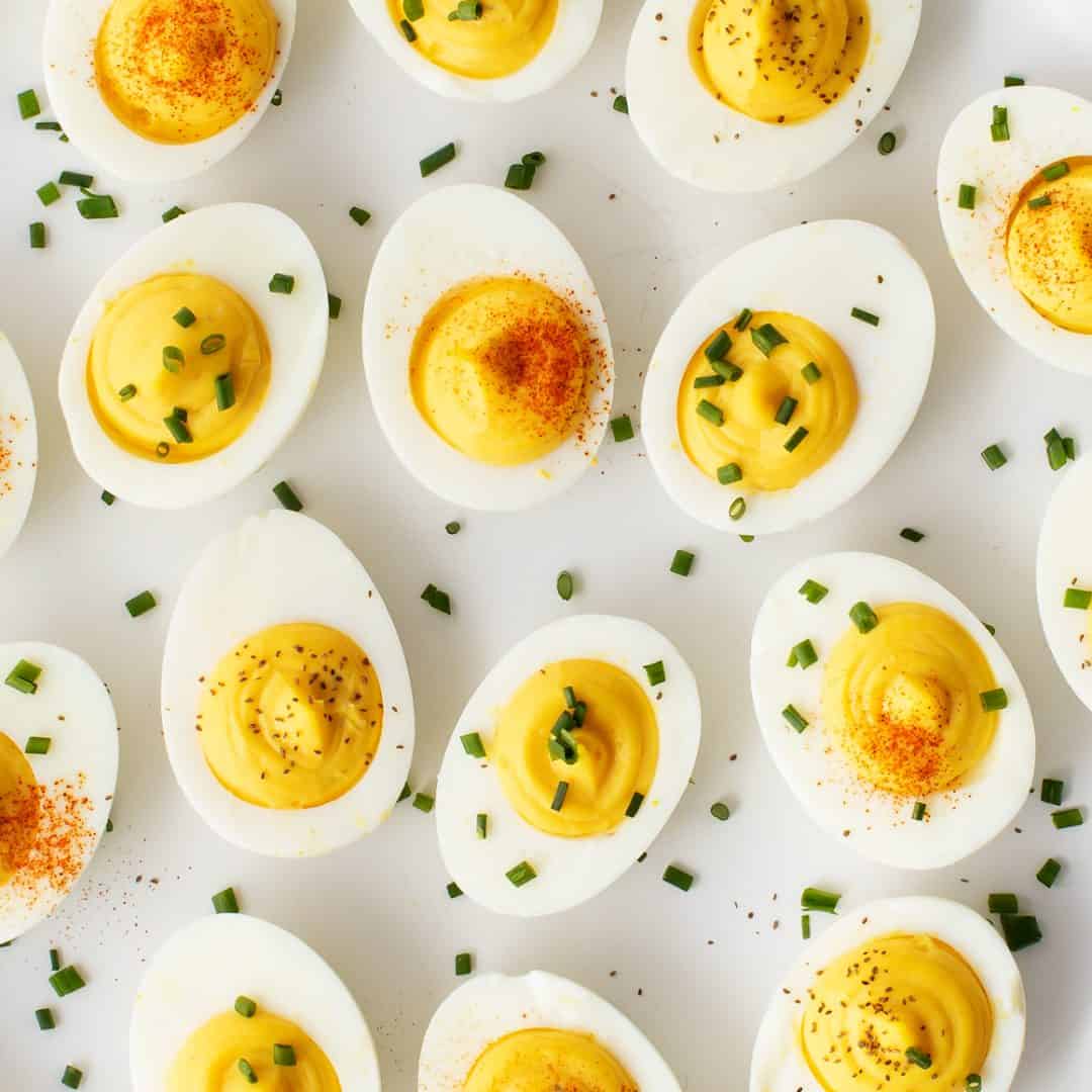 Deviled eggs topped with smoked paprika, chopped chives, or celery seed