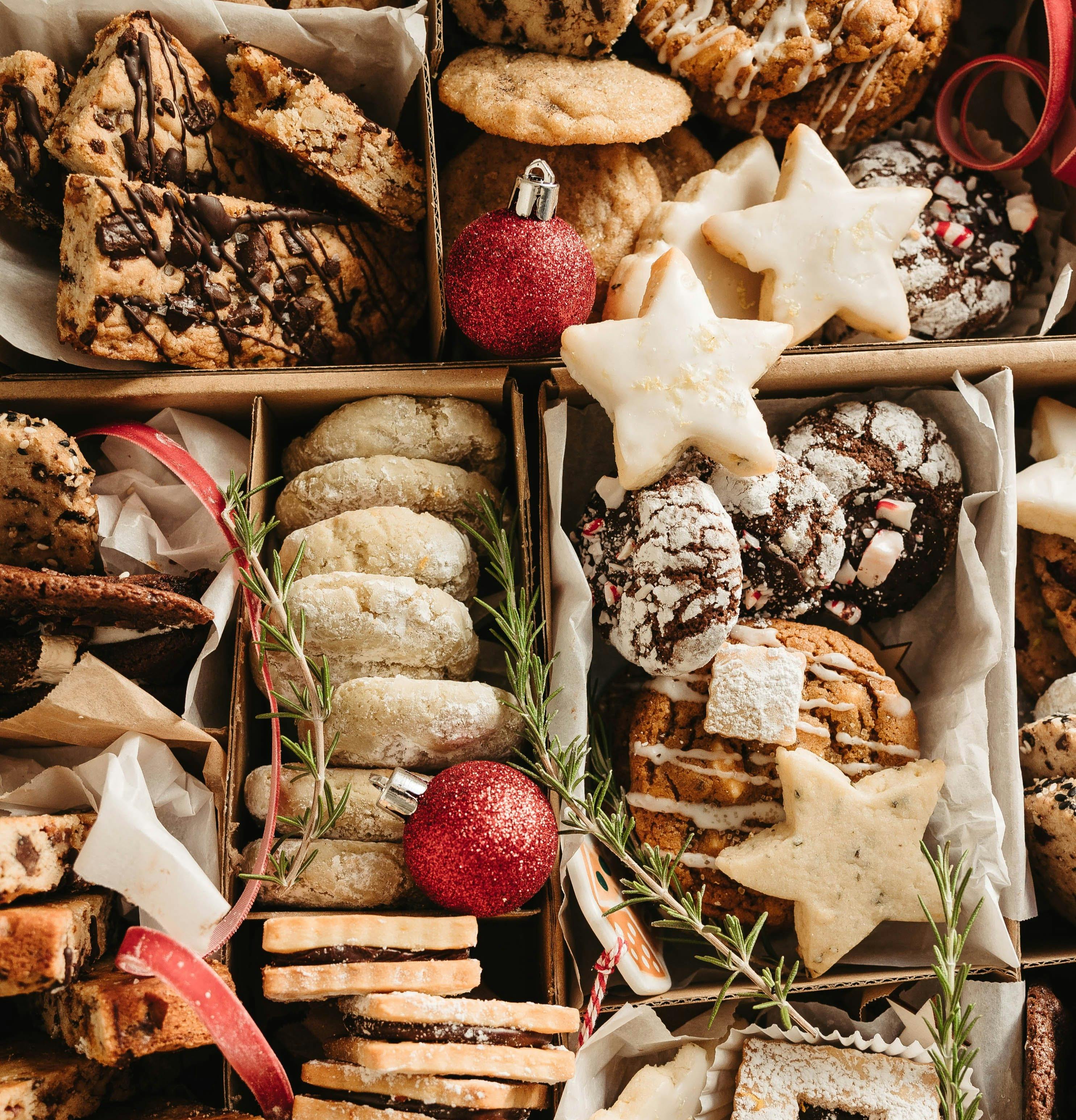 Holiday cookie box with ornaments, ribbon, and rosemary