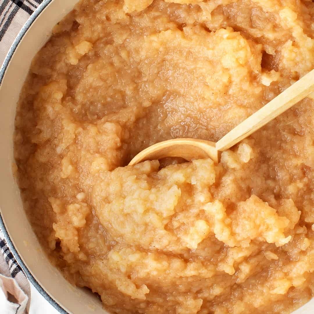Pot of homemade applesauce with wooden spoon