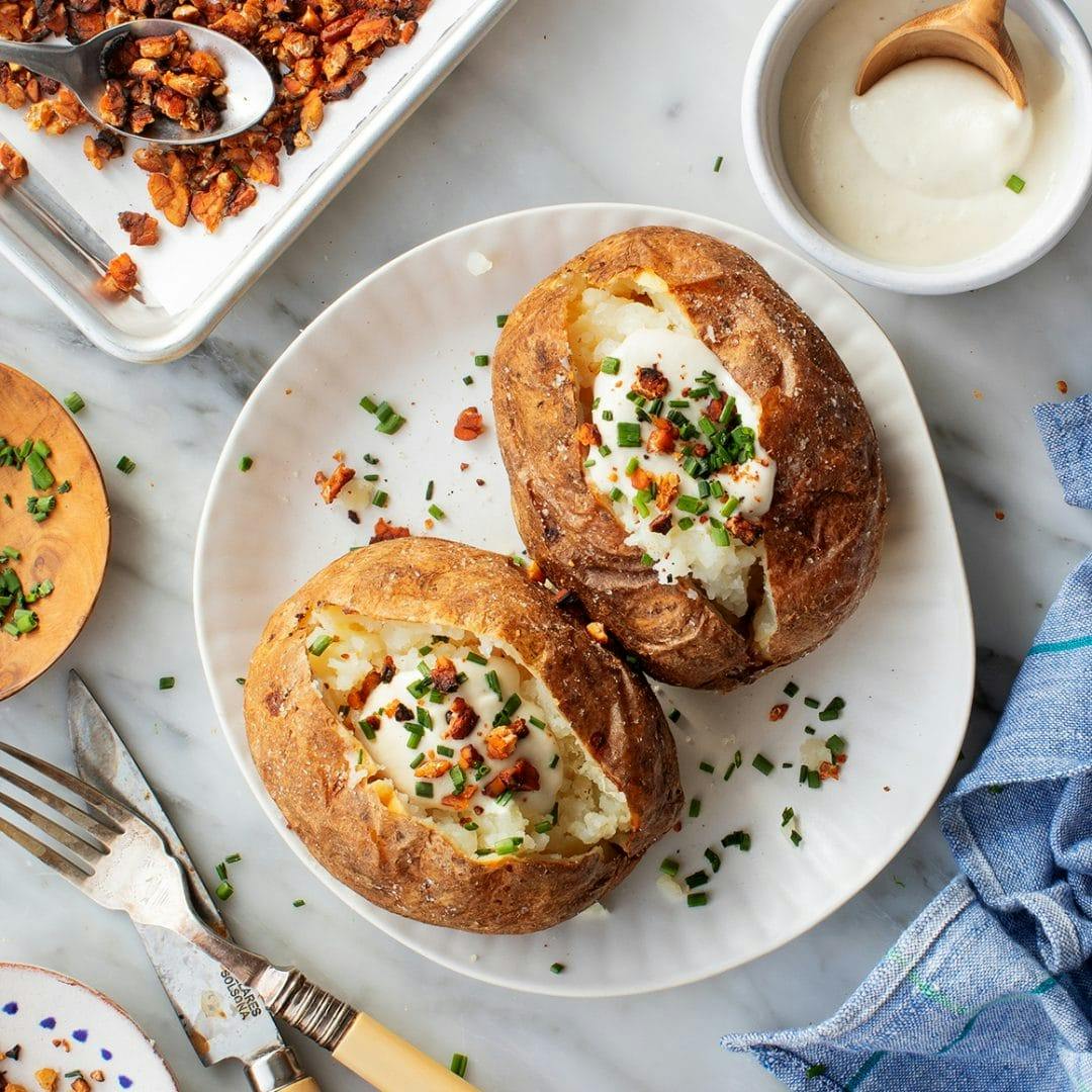 Baked potatoes with cashew sour cream, chives, and tempeh bacon