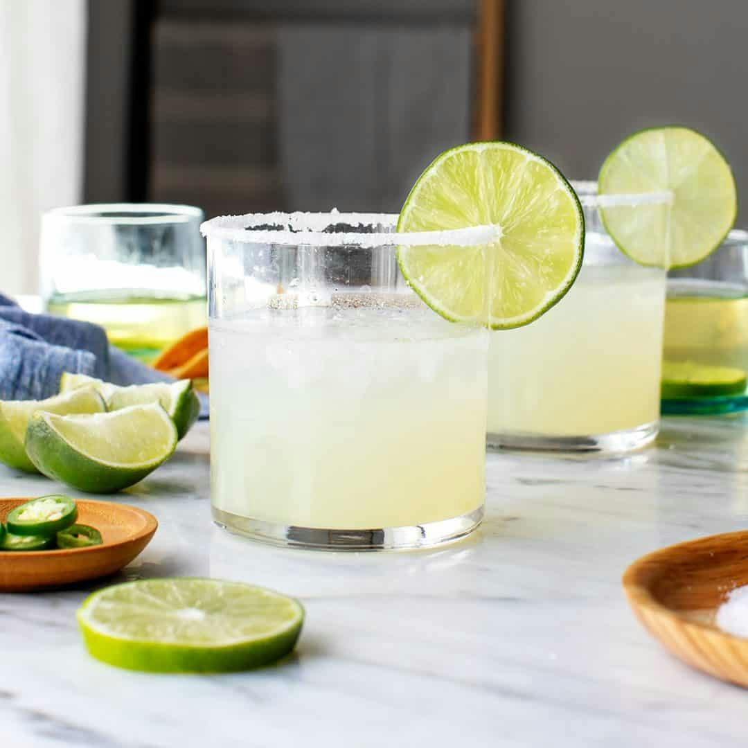 Two margaritas with lime wheels