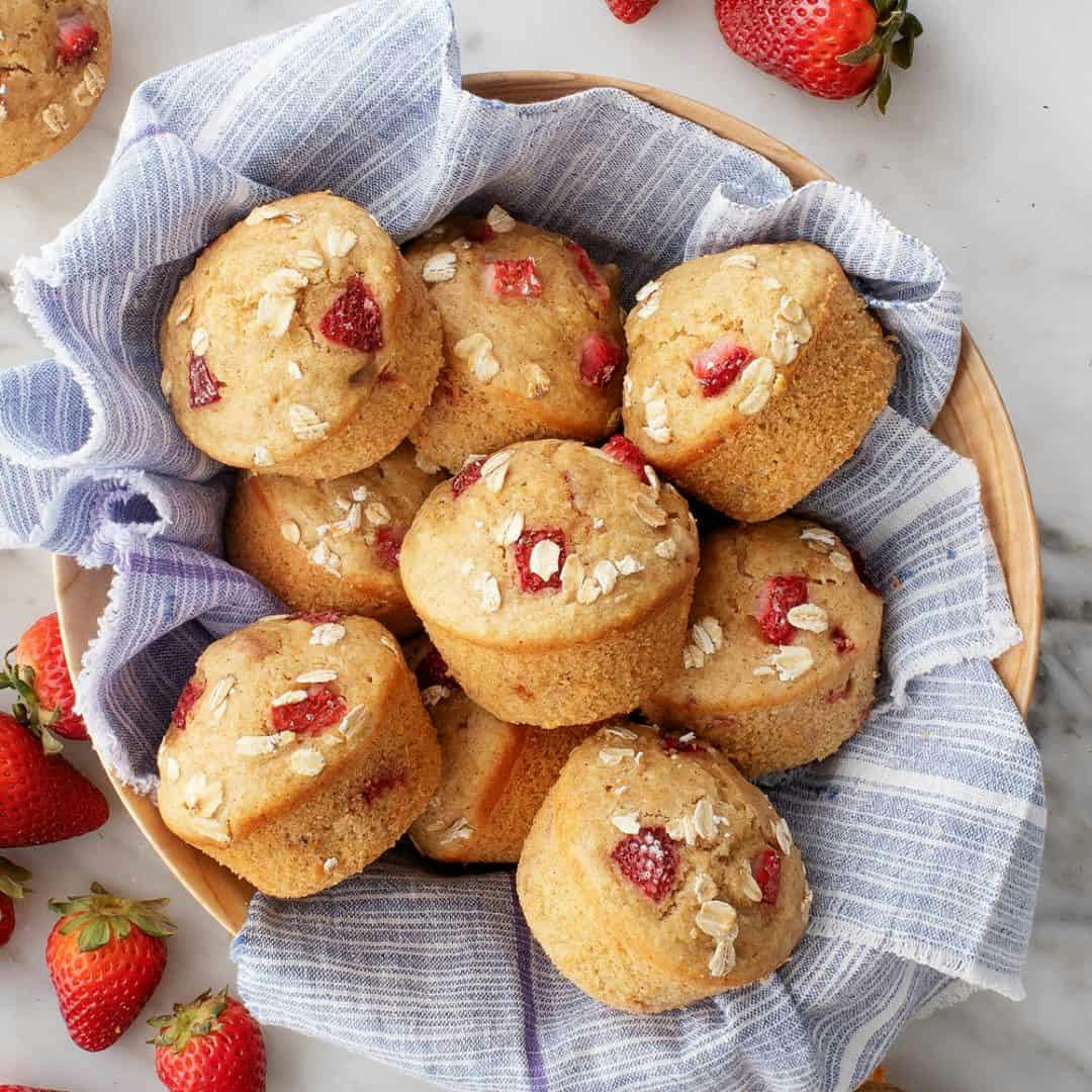 Strawberry muffins in a basket with striped blue linen