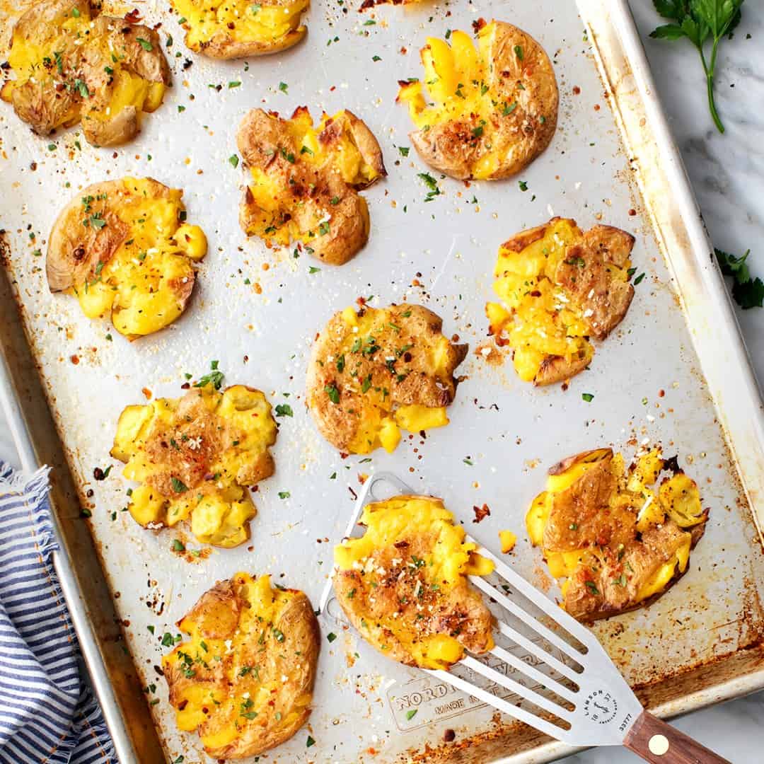 Crispy smashed potatoes on a baking sheet