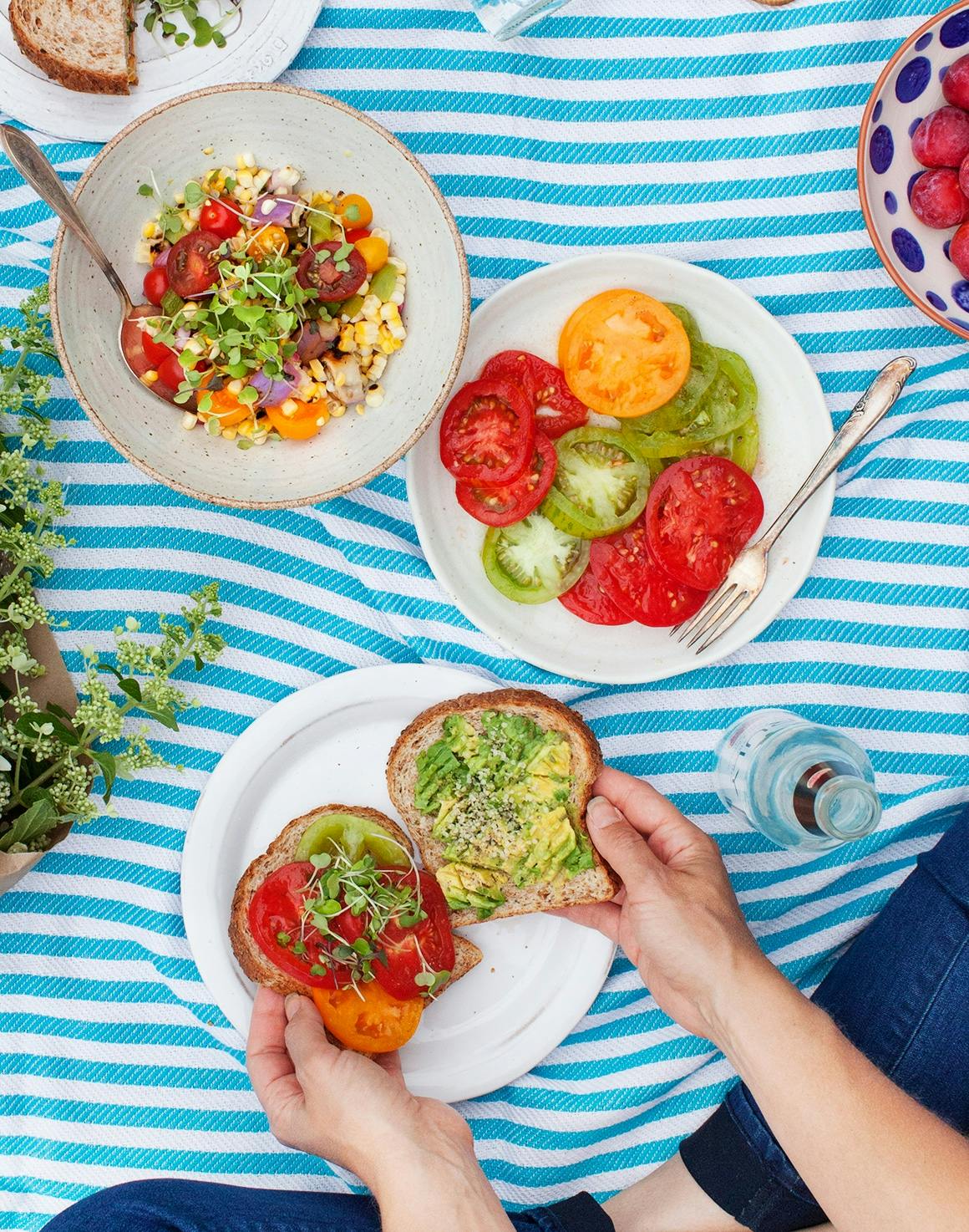 Salad and sandwiches on a picnic blanket