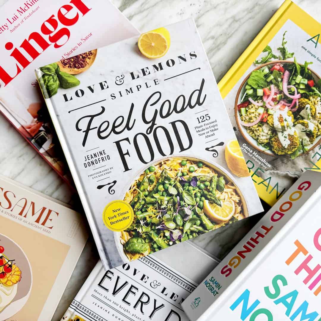 Pile of cookbooks including Love & Lemons Simple Feel Good Food, Good Things, Linger, and Sesame