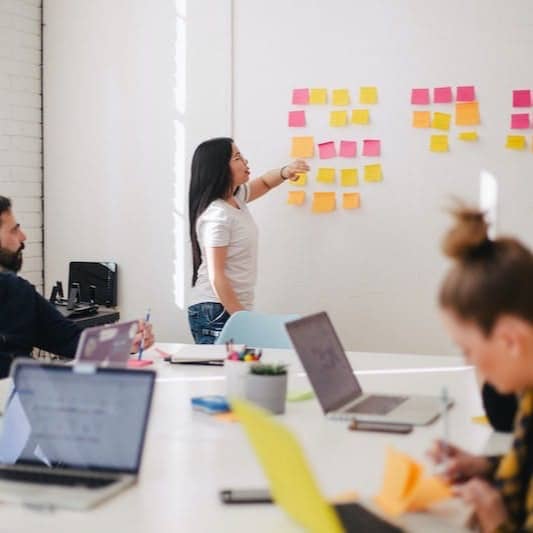 woman placing sticky notes on wall