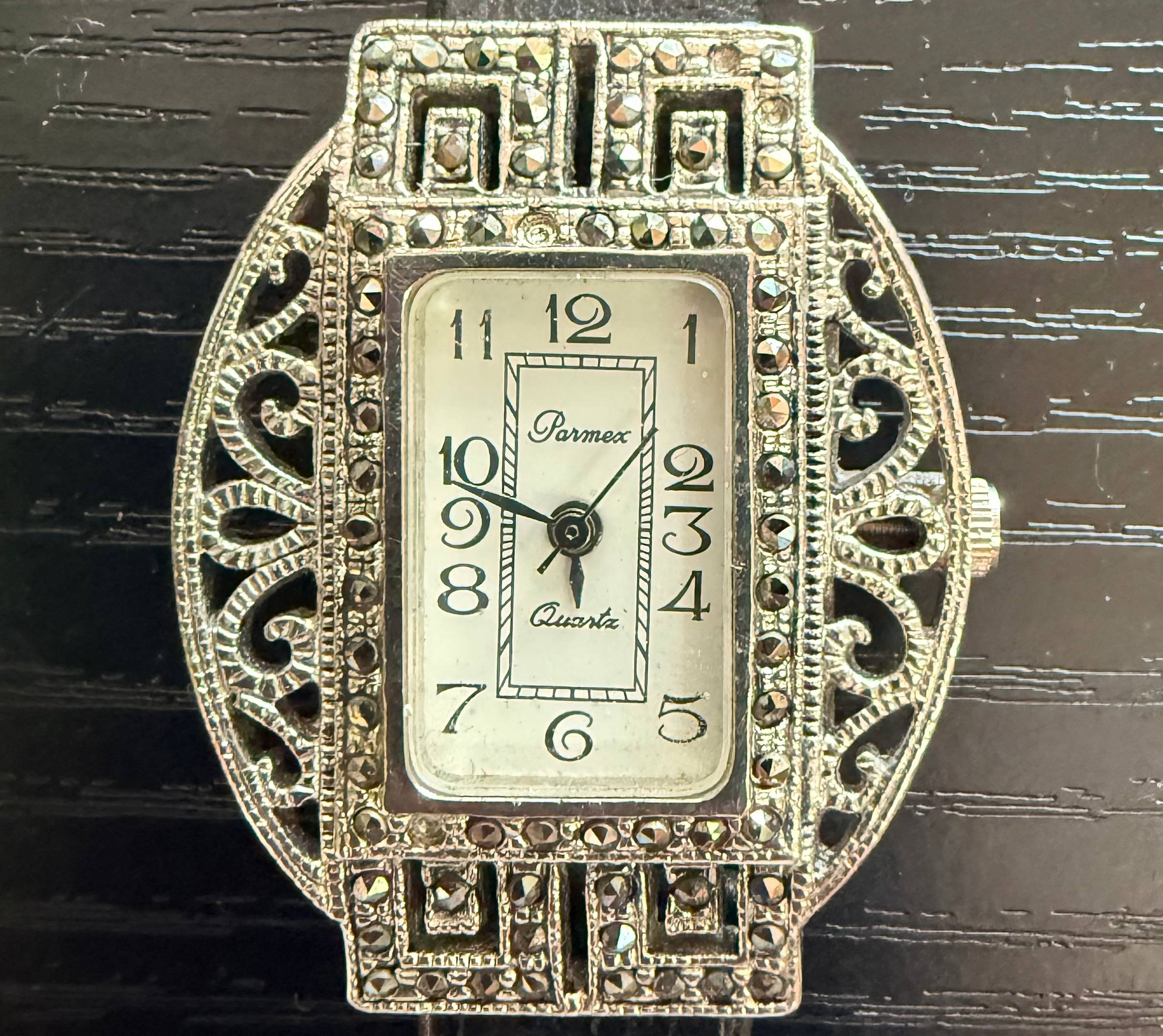A silver watch showing time