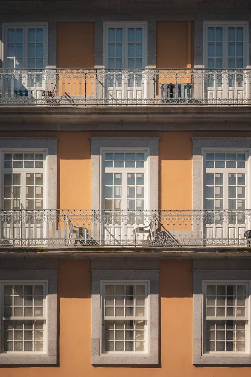 Orange building facade with white windows and balconies.