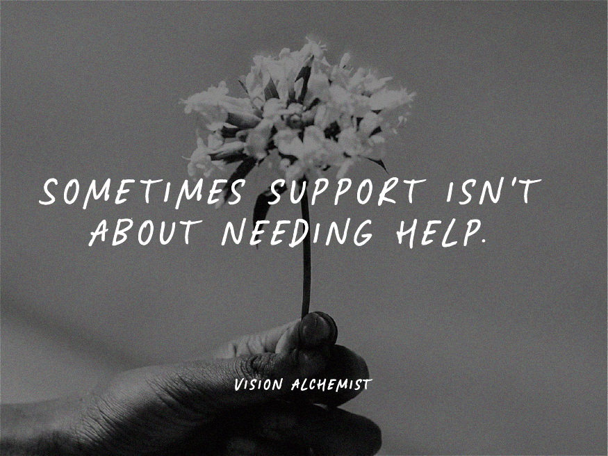 A black-and-white photograph of a hand holding a small white flower with the words "Sometimes support isn't about needing help." overlaid on the image.