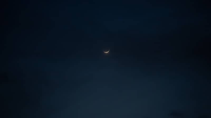 the moon is seen through the clouds in the night sky