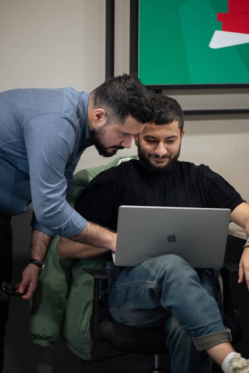 Two men are looking at a laptop computer