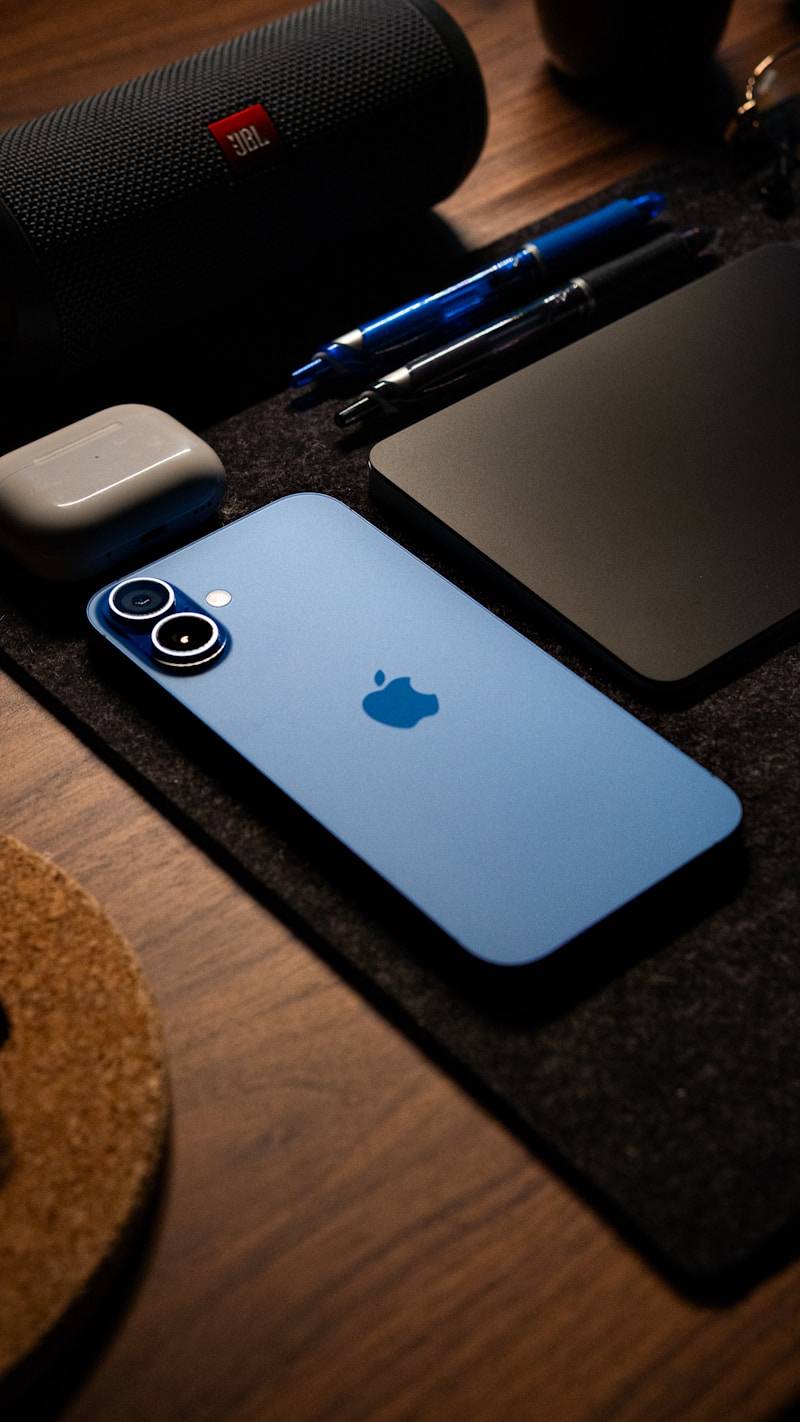 A wooden table topped with a phone and other electronics