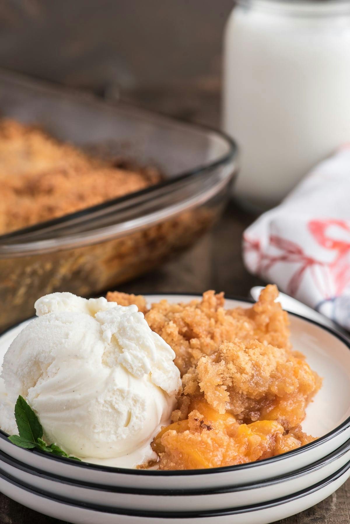 Peach crumble on a plate with a scoop of ice cream.