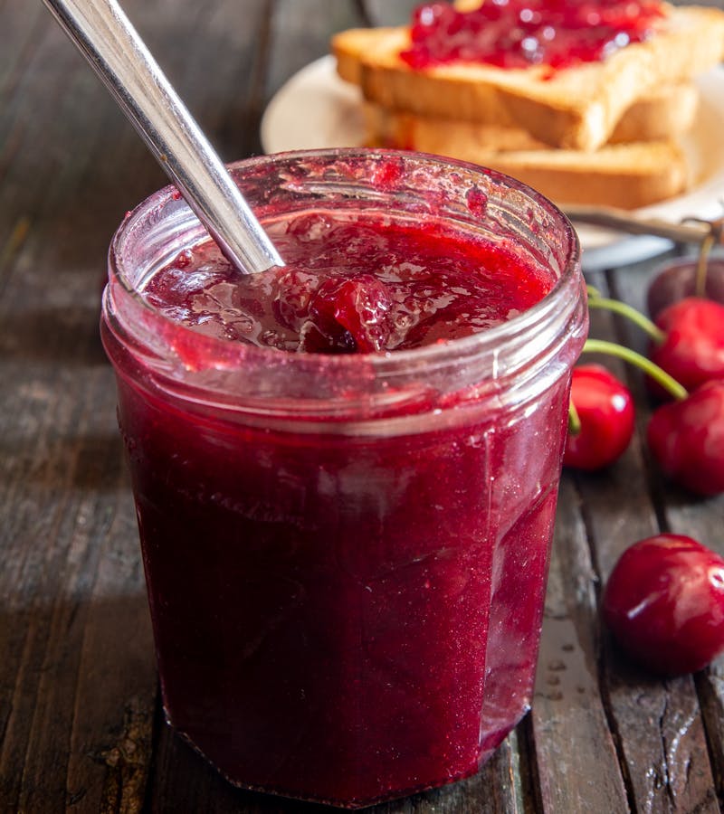 Cherry jam in a glass jar.