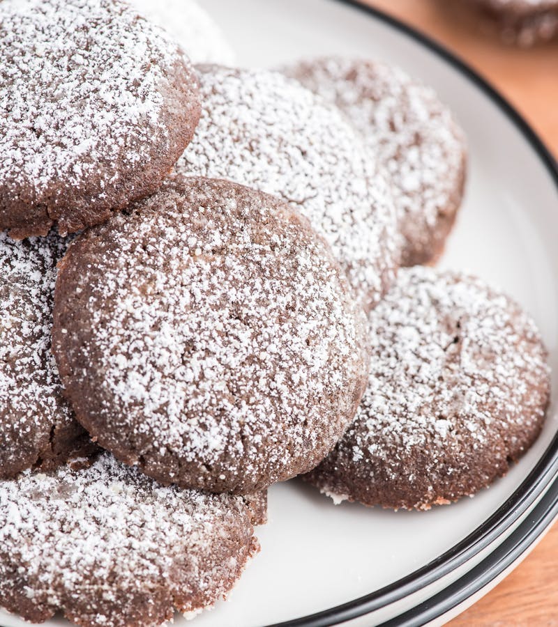 Dark chocolate sugar cookies on a white plate.