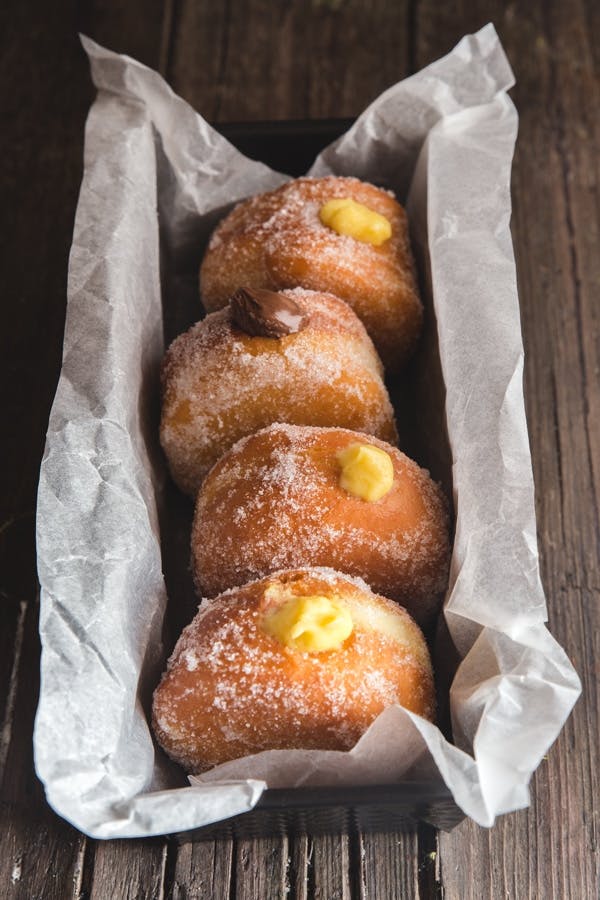 Four Italian donuts in a black loaf pan.