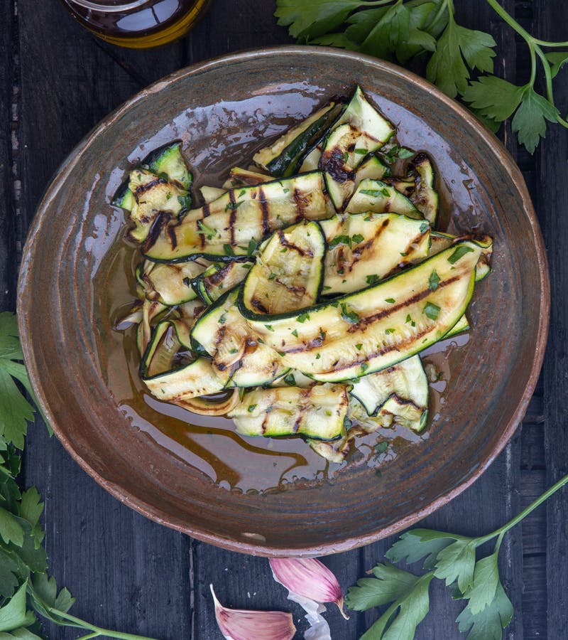 Grilled zucchini in a brown dish.