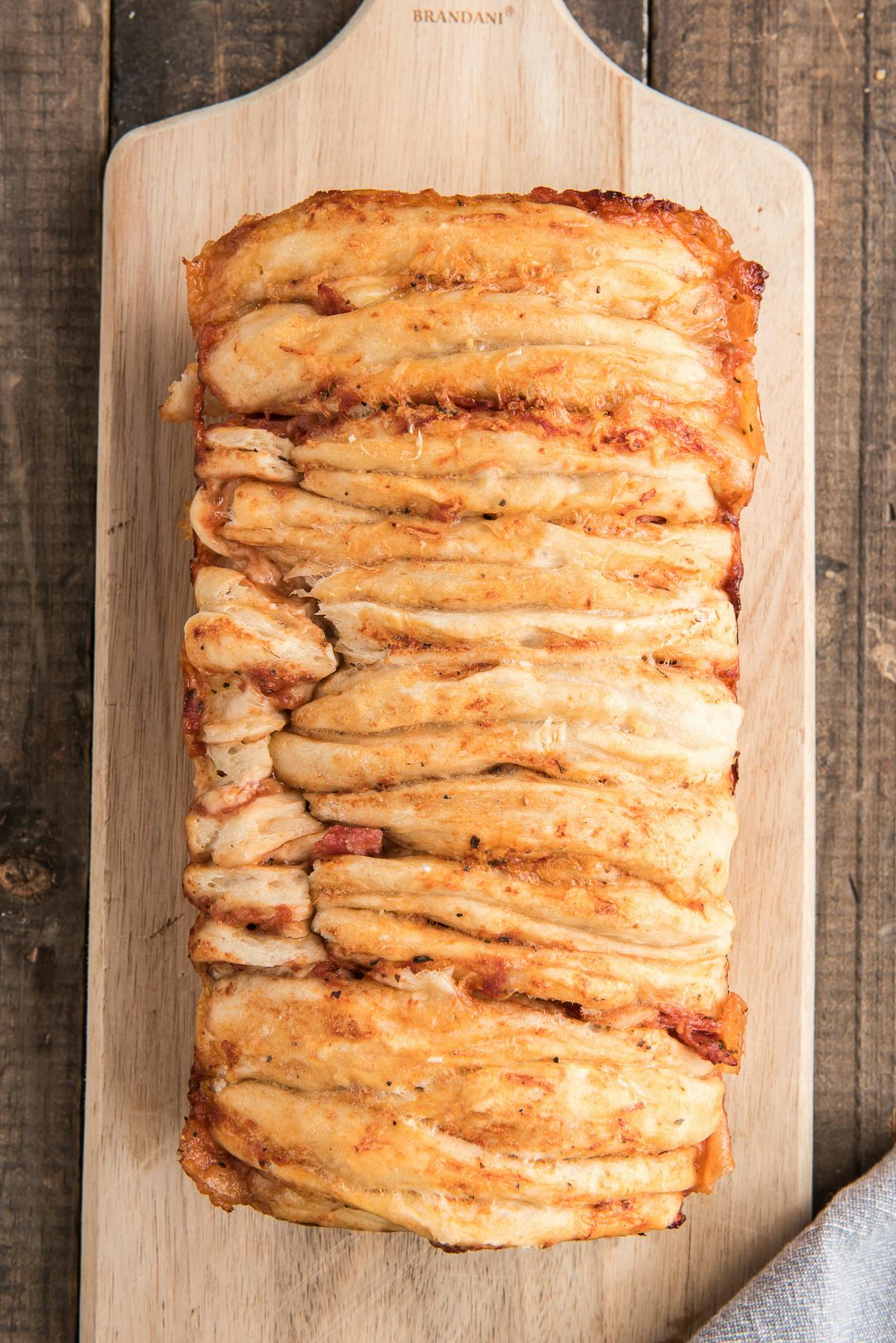 Pull apart pizza bread on a wooden board.