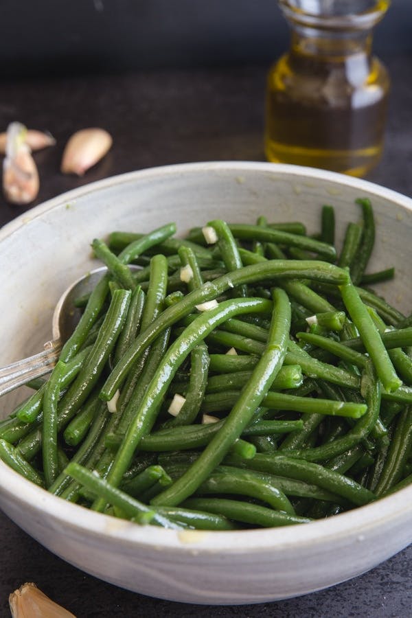 Simple Italian Green bean recipe in a white bowl.