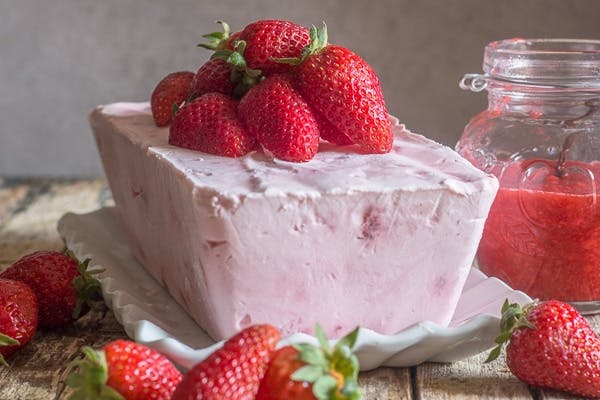 semifreddo on a white tray with strawberries on top.