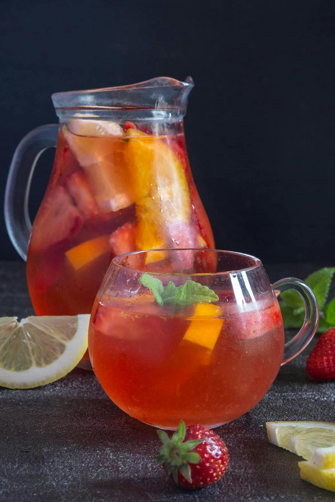 Refreshing easy strawberry sangria in a jug and a glass.