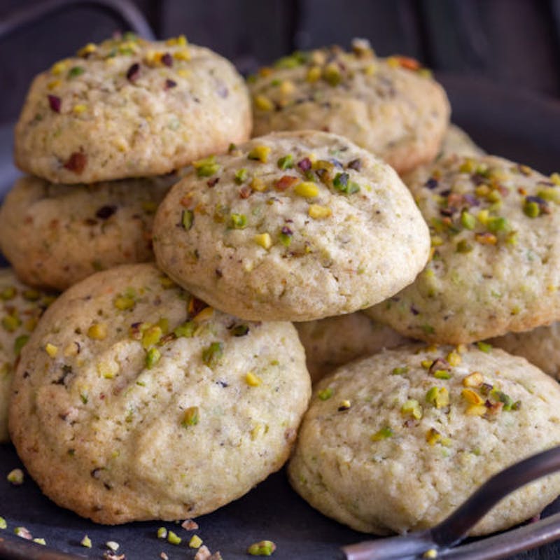 Pistachio cookies on a black plate.