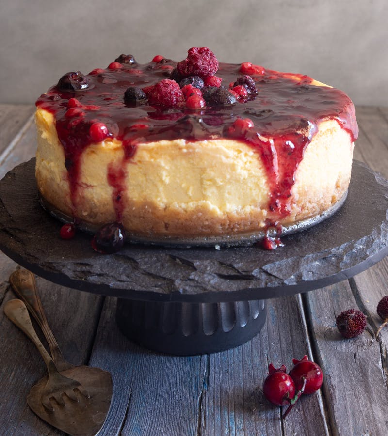 Cheesecake on a black cake plate.