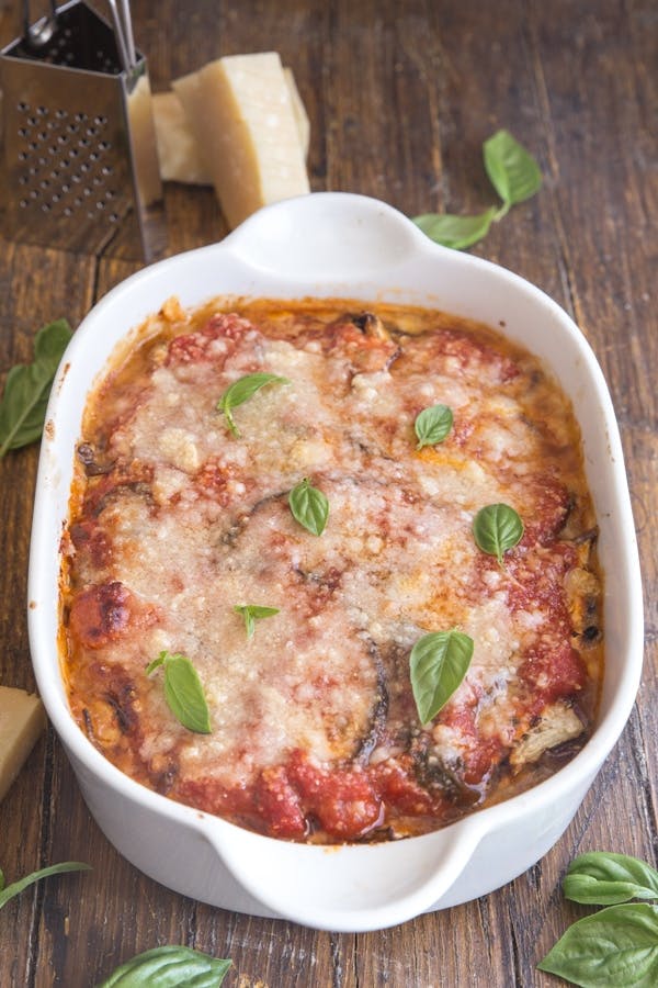 Baked eggplant parmesan in a white baking dish.