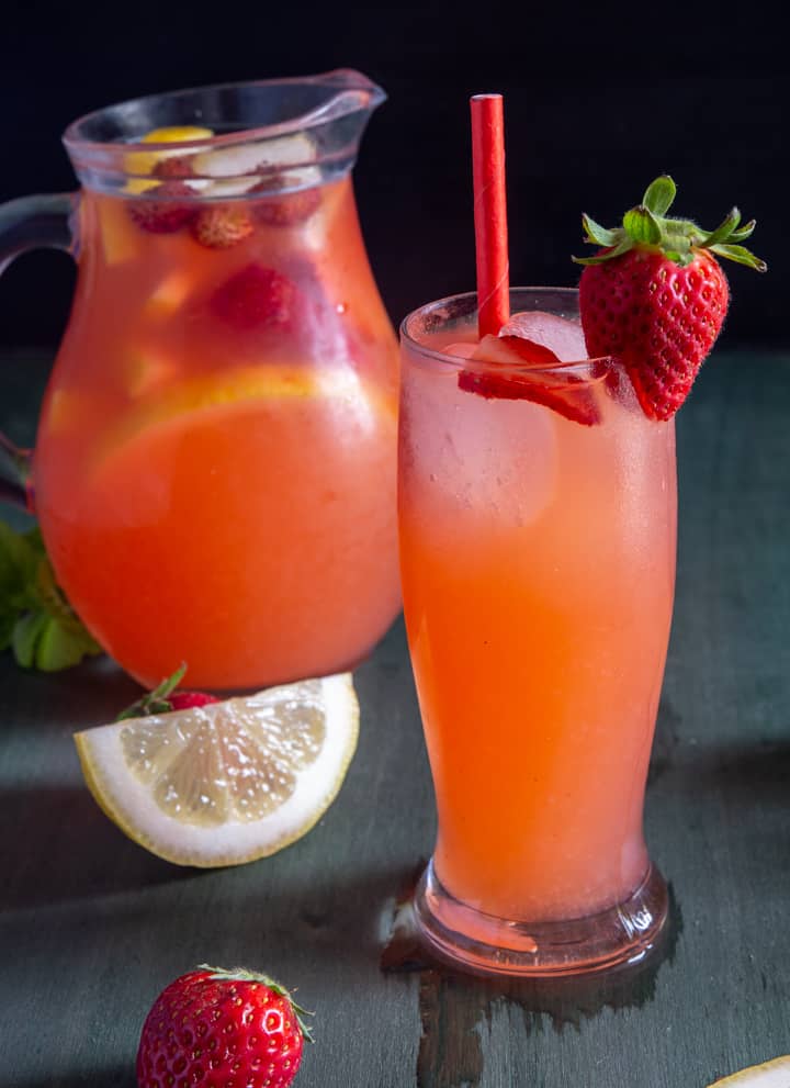 Strawberry lemonade in a jug and a glass.