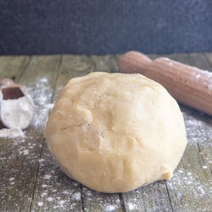 Pie dough on a wooden board.