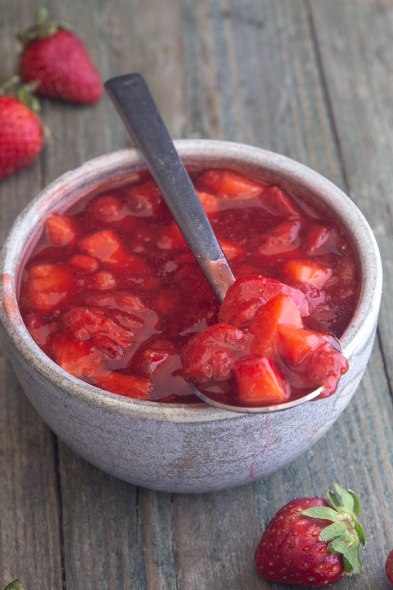 Easy strawberry sauce in a grey bowl.