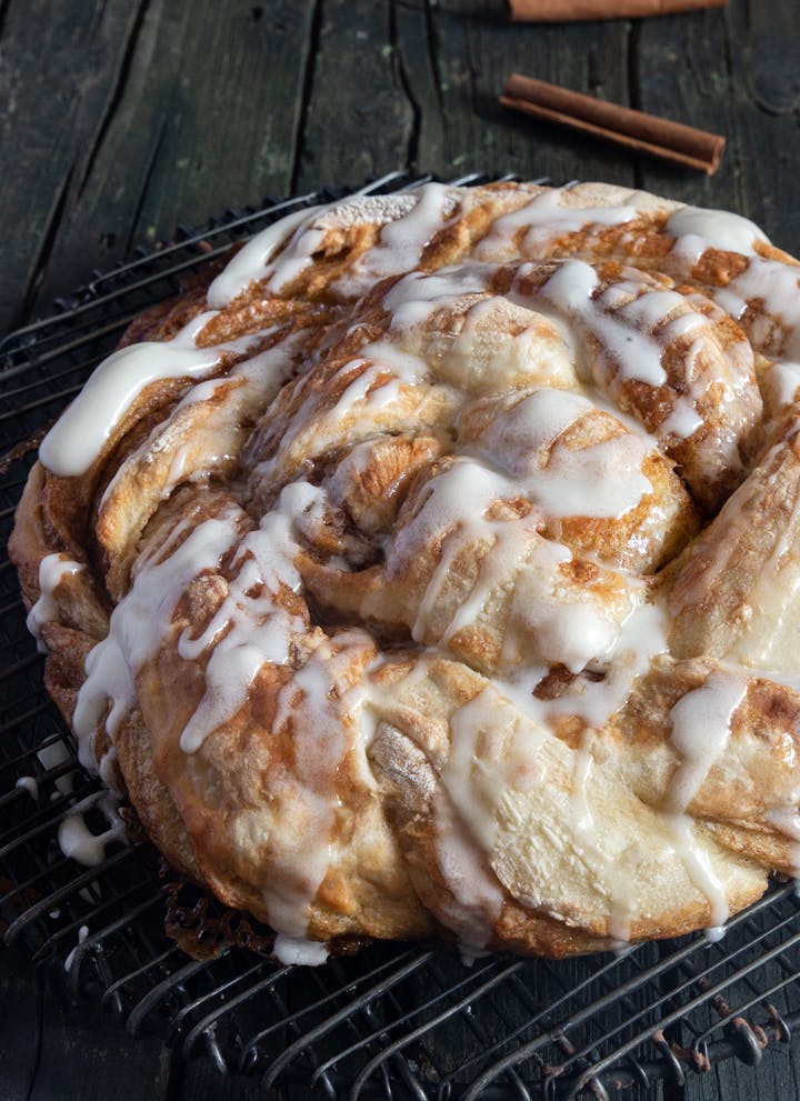 Refrigerator dough braided cinnamon bread on a wooden board.