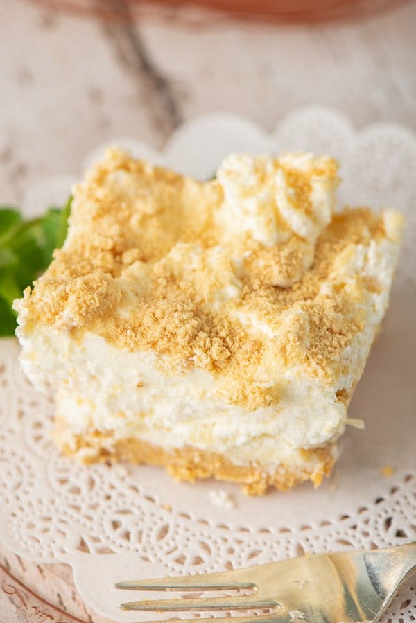 A slice of pineapple cream dessert on a white plate.