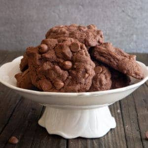 Chocolate chip cookies on a white plate stand.