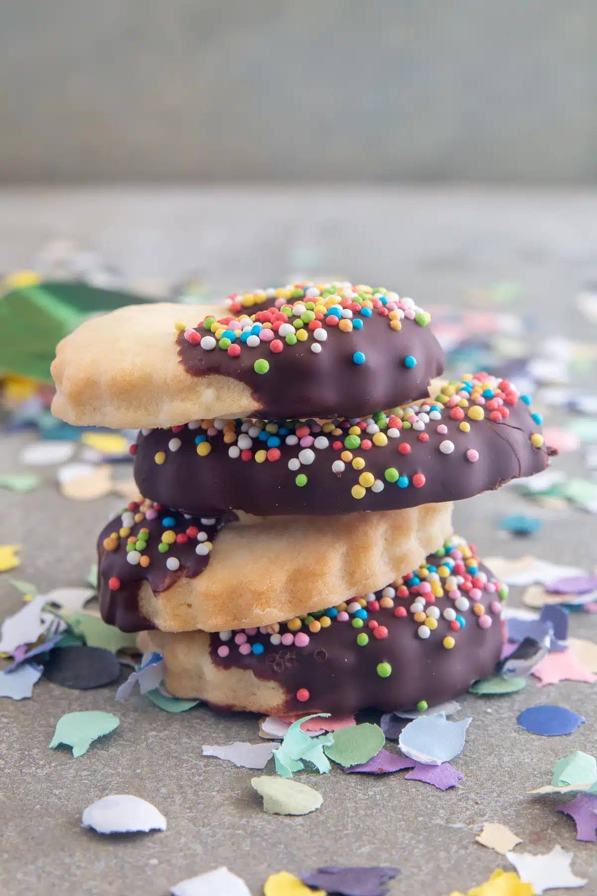 Four carnival sprinkle cookies stacked..