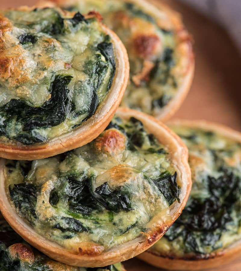 Ricotta spinach tarts on a board.