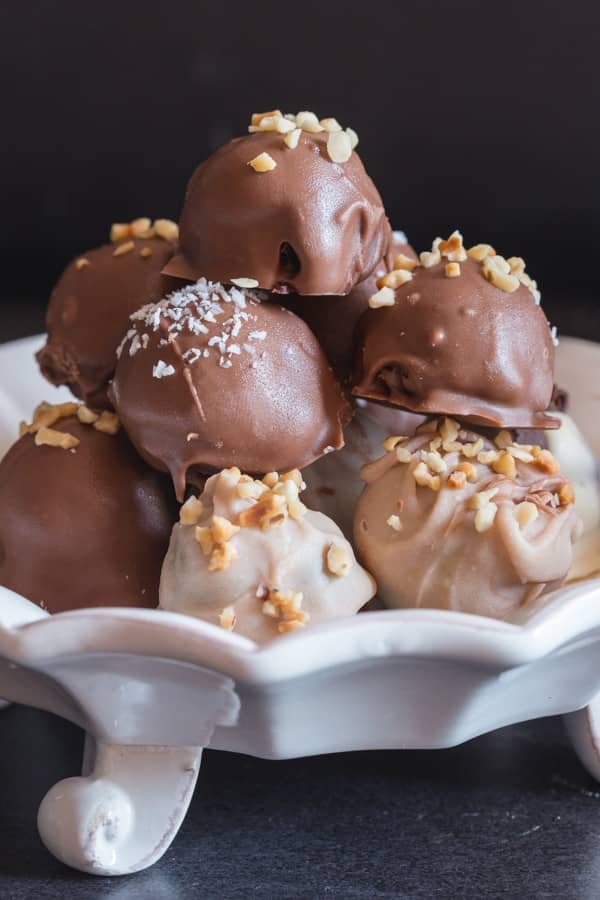 Homemade chocolate truffles on a white plate.
