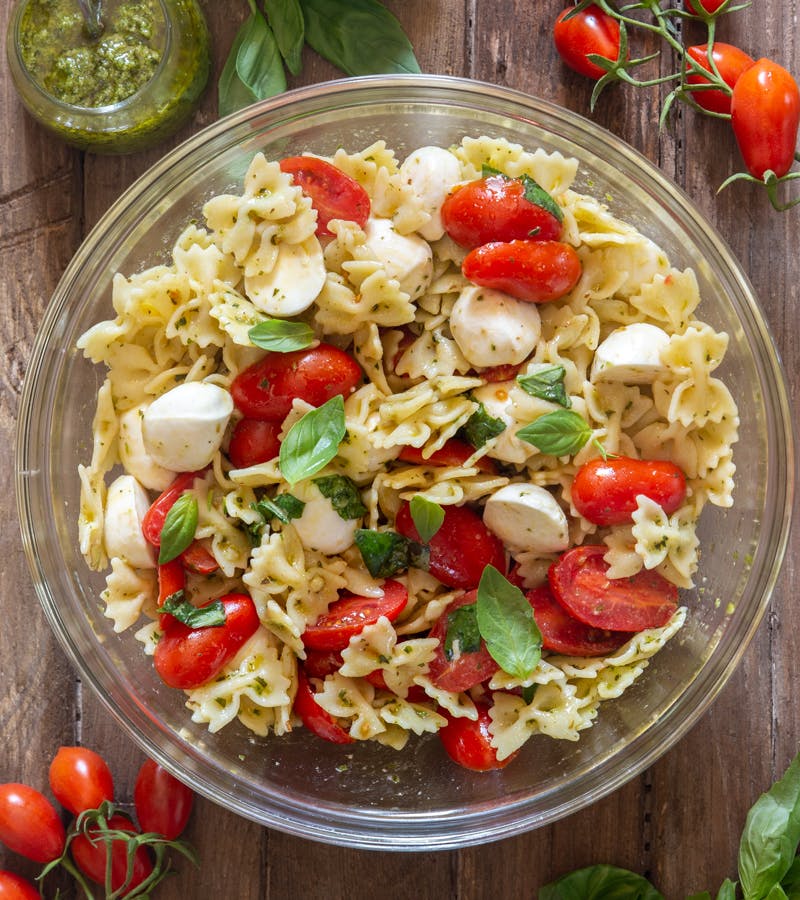 Caprese pasta salad in a glass bowl.