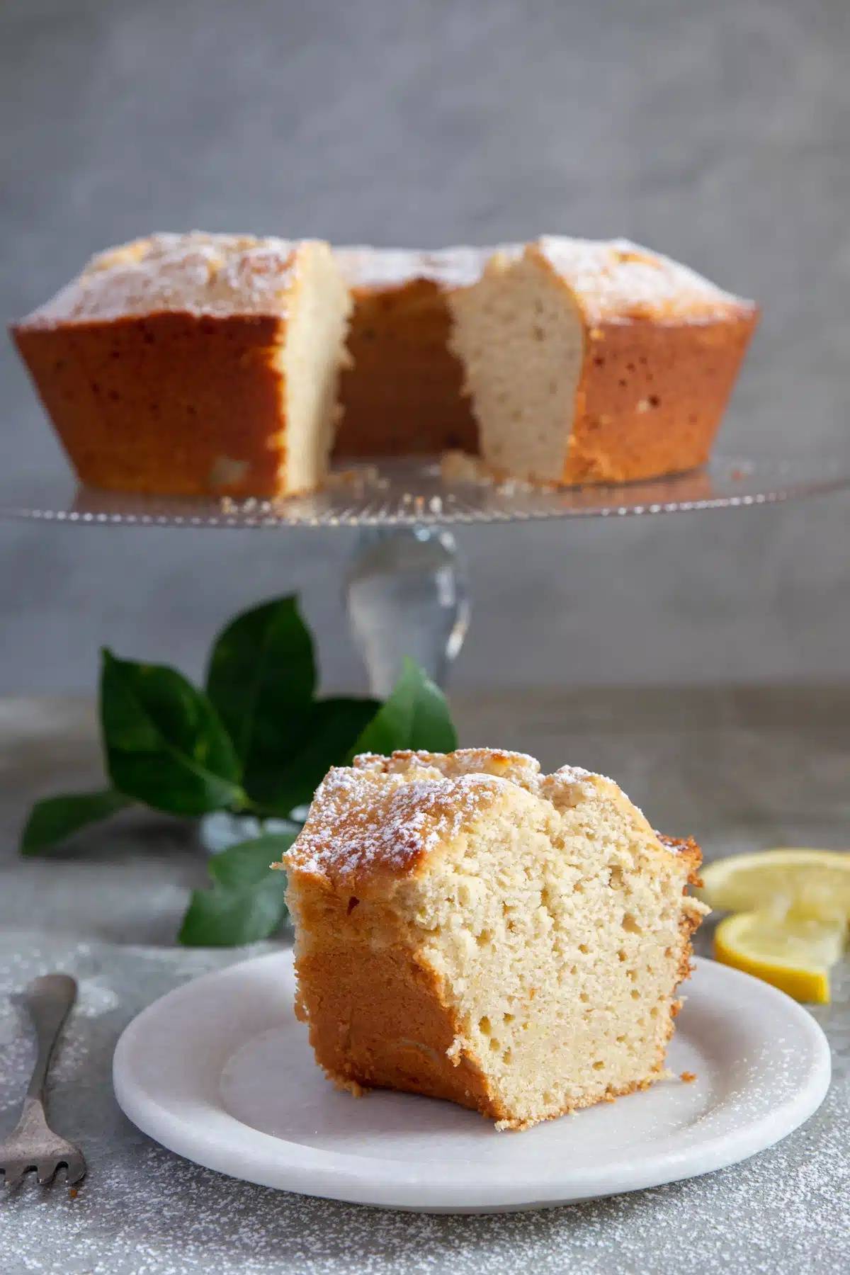 Lemon ricotta cake with a slice cut.