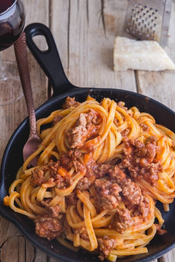 Authentic Bolognese sauce with pasta in a black pan.