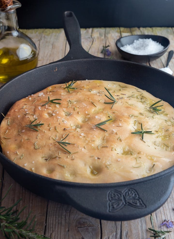 Sourdough focaccia in a black pan.