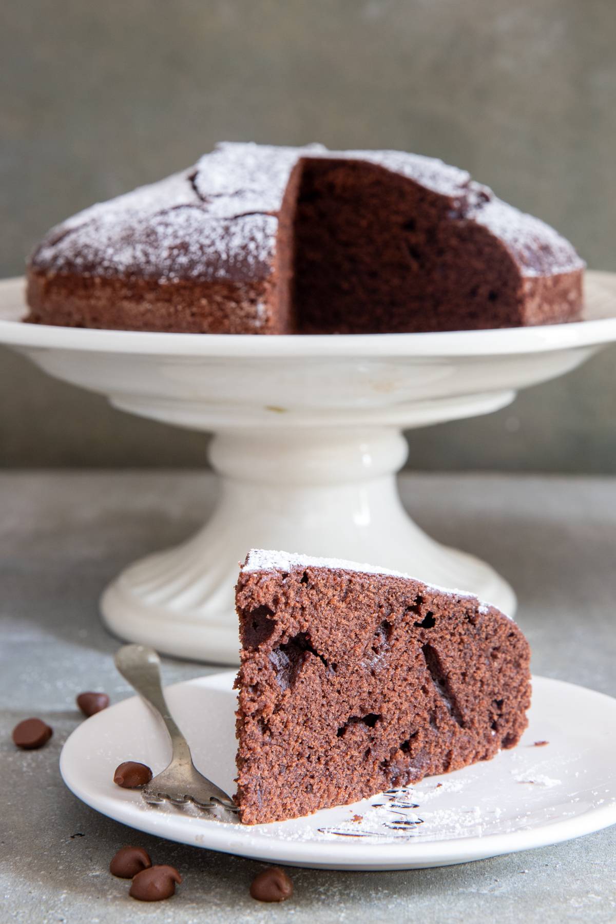 Simple chocolate water cake with a slice on a white plate.